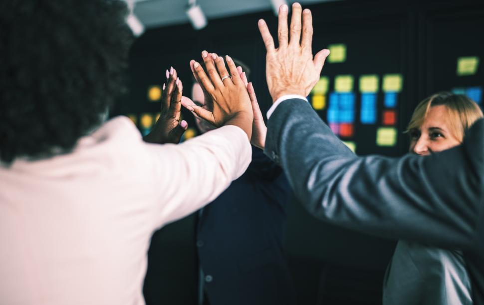 Coworkers celebrating team success with a high five in New York